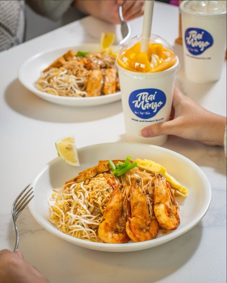 Shrimp pad Thai beside a Thai Mango smoothie cup